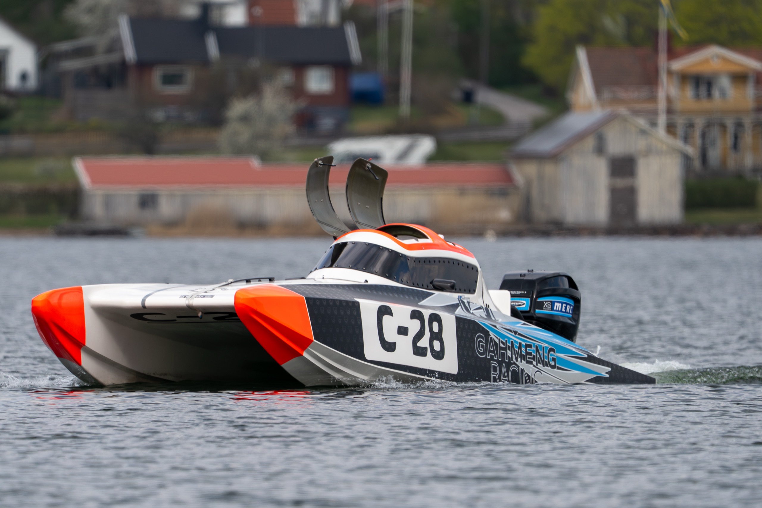 Offshore-racingbåt i Stockholms skärgård med röda sjöbodar i bakgrunden